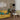 a living room with a yellow couch and a white coffee table