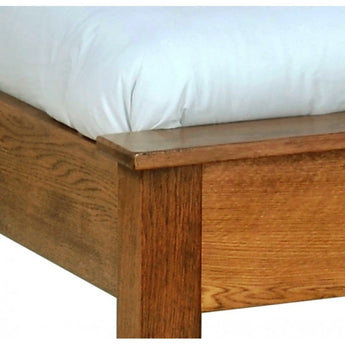 a wooden bed with a white blanket on top of it 