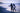 person walking on seashore holding surfboard