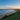 green grass field near sea under blue sky during daytime