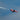 a red and white plane flying in the sky