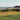 a grassy field next to a body of water