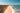 a sandy beach with a body of water in the background