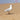 a seagull standing on the beach with a piece of bread in its mouth