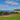 a grassy field next to a body of water