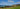a grassy field next to a body of water