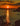 a sunset over a body of water with trees in the foreground