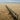 a broken fence on a beach with a body of water in the background
