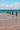 Wooden posts stand in the ocean, with waves.
